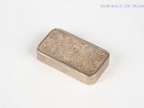 a silver box with a design on it on a white surface