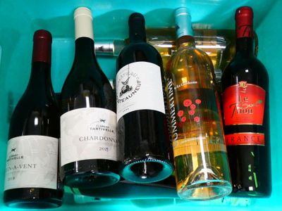 many bottles of wine sitting in a plastic container
