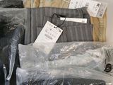 several pairs of pants are wrapped in plastic bags on a shelf