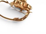 a close up of a gold object on a white surface