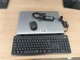 un ordinateur portable et un clavier posés sur un bureau, avec une souris à côté