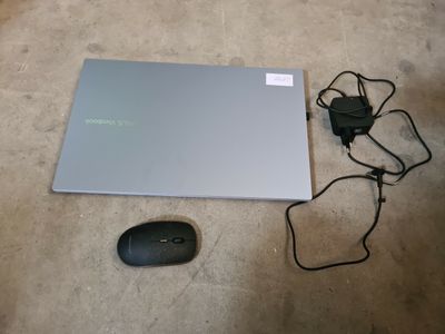 un ordinateur portable et une souris posés l'un à côté de l'autre sur le sol