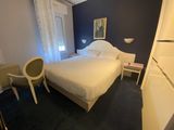 un lit blanc placé dans une chambre, près d'une fenêtre