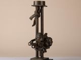 bronze sculpture of a man with a hat on a pole