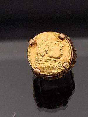 an image of a gold ring with a coin on it