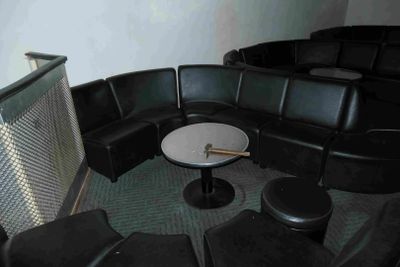des chaises en cuir noir et une table ronde dans une pièce