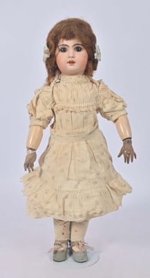 une poupée à l'ancienne aux cheveux bruns et vêtue d'une robe blanche