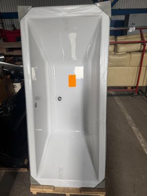 une baignoire blanche posée sur une palette dans un entrepôt
