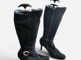 pair of black leather boots with a gold buckle on the heel