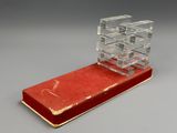 une image représentant un livre rouge surmonté d'un cube de verre