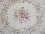 a white rug with pink flowers on it in a room