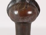 a brown vase that has a black handle on it