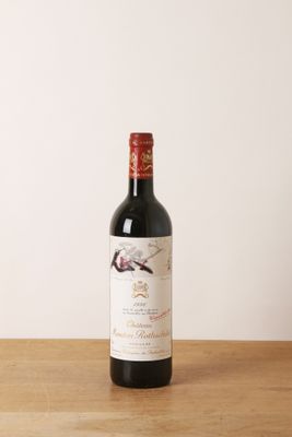 la bouteille de vin rouge est posée sur une table en bois