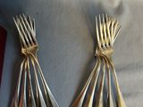 three forks and spoons on a table with a red napkin