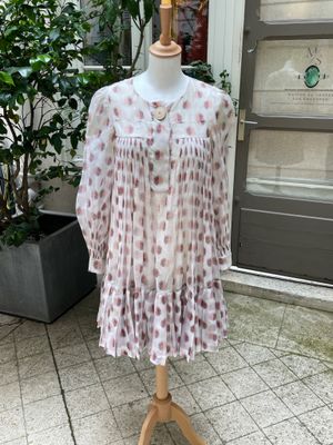 une robe posée sur un mannequin devant une porte