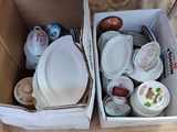 two boxes with plates and bowls in them on the floor