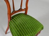 a small chair with a green seat on a white background