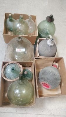 several glass bottles are in a box on a white surface