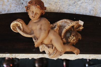 a figurine of a child on a shelf next to a vase