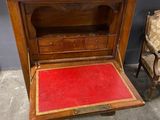 a small wooden cabinet with a red carpet on the floor