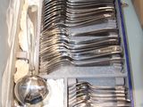 a lot of silverware in a blue case on a table