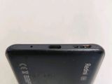the back of a black cell phone sitting on top of a white table