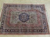un tapis posé à même le sol, orné d'un motif bleu et rouge