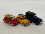 three toy cars sitting next to each other on a white surface