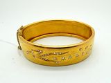 an image of a close up of a gold bracelet on a white surface
