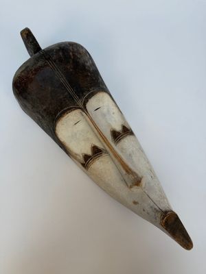 une image montrant un gros plan d'un objet en bois posé sur une surface blanche