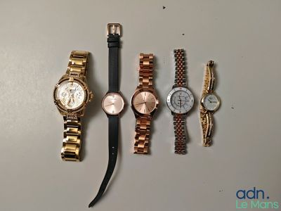 Plusieurs montres différentes sont alignées sur une table