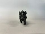 a black dog figurine sitting on top of a white surface