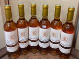 six bottles of wine are lined up in a row on a table
