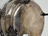 a silver plate on the wall with a tag on it