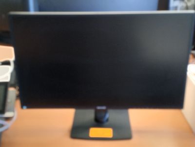 un écran d'ordinateur posé sur un bureau dans une pièce