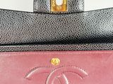 a close up of a pink and black purse on a white surface