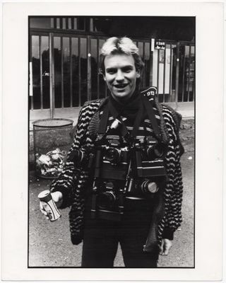photographie en noir et blanc d'un homme vêtu d'une veste en cuir tenant une canette de soda