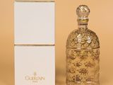 un flacon de parfum et son coffret sur fond beige