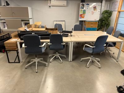 des tables et des chaises dans une pièce où il y a beaucoup de cartons par terre