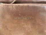 the brown leather bag is open and has a zipper on it