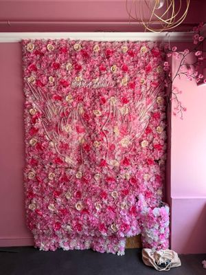 un grand mur recouvert de fleurs roses dans une pièce ornée d'un lustre