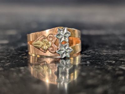 un gros plan d'une bague en or et en argent posée sur une table