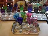 many different colored glasses on a tray on a table