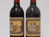 two bottles of wine sitting next to each other on a white surface