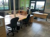 a room with a desk, chairs, and a computer on it