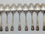 six spoons are lined up in a row on a white surface