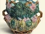 un vase vert contenant des fleurs roses, sur fond blanc