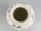 a white vase with a green and blue design on it