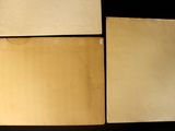 three pieces of old paper are sitting on a black surface