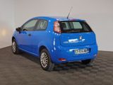 the small blue car is parked on a checkered tile floor